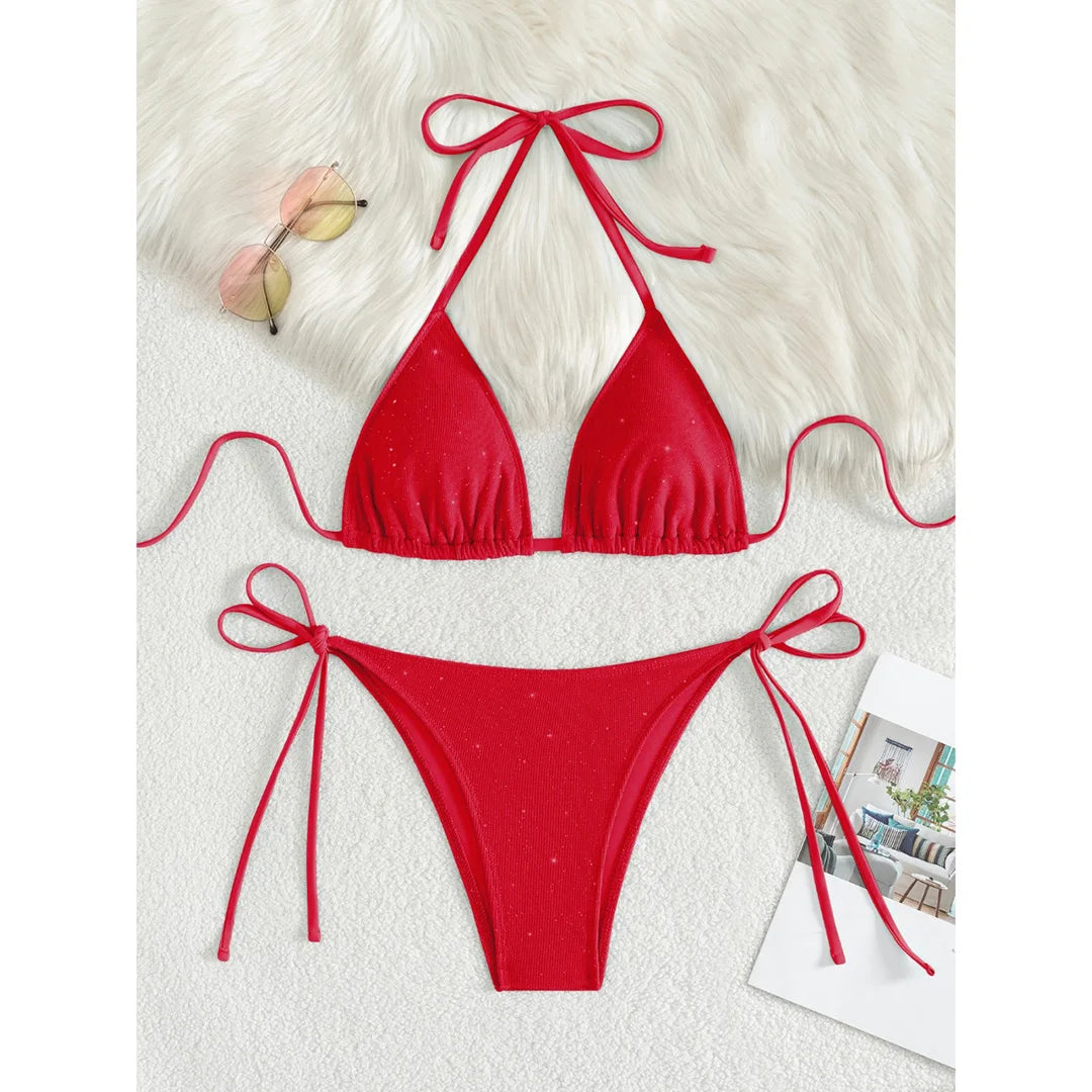 An elegant two-piece swimwear featuring a sparkling glitter finish, halter neckline, and high-leg cut, designed for a radiant and confident feminine beach look
