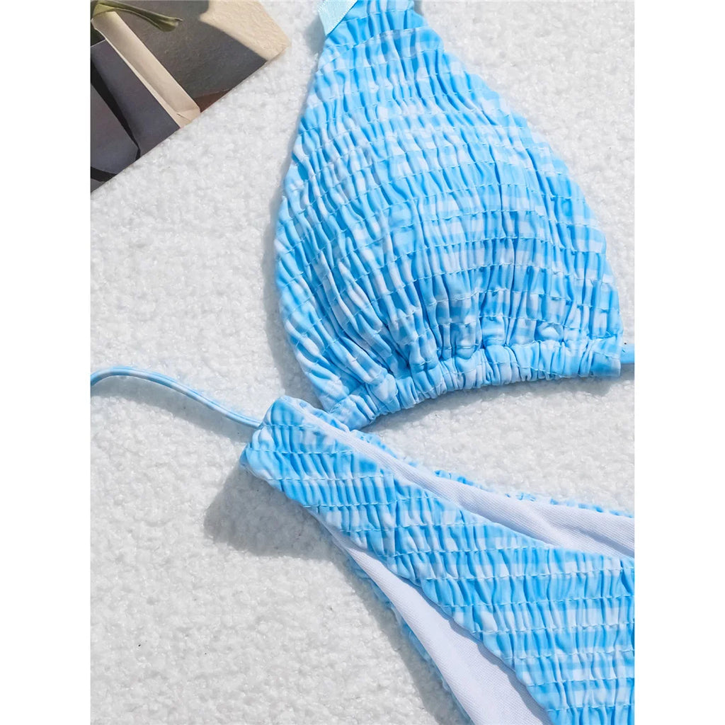 An elegant two-piece swimwear featuring a refined plaid pattern, soft wrinkled texture, and delicate bow detail, designed for a feminine and effortlessly chic beach look