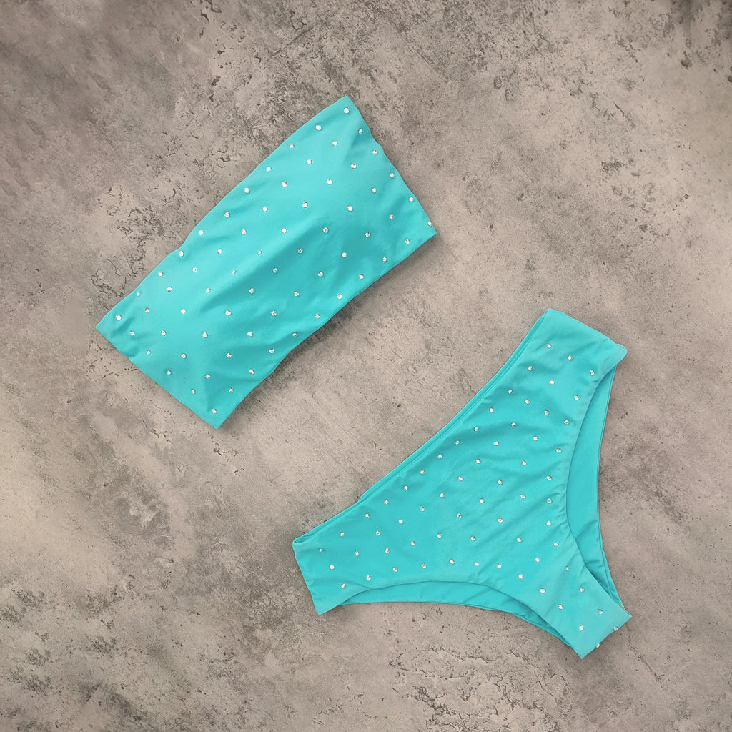 An elegant reversible two-piece swimwear featuring a bandeau top with cross-halter detail and a high-waisted bottom, designed for versatile, feminine summer style