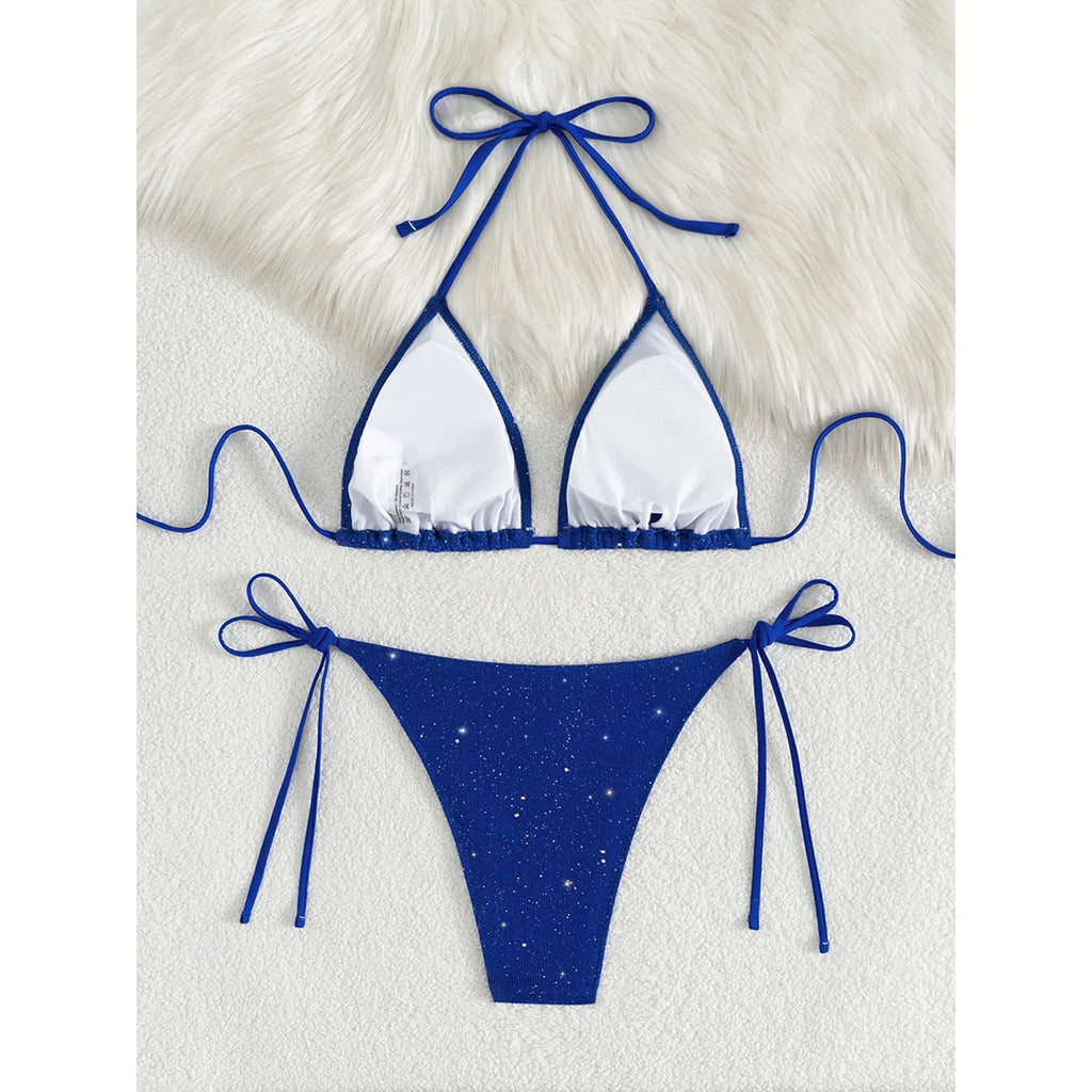 An elegant two-piece swimwear featuring a sparkling glitter finish, halter neckline, and high-leg cut, designed for a radiant and confident feminine beach look