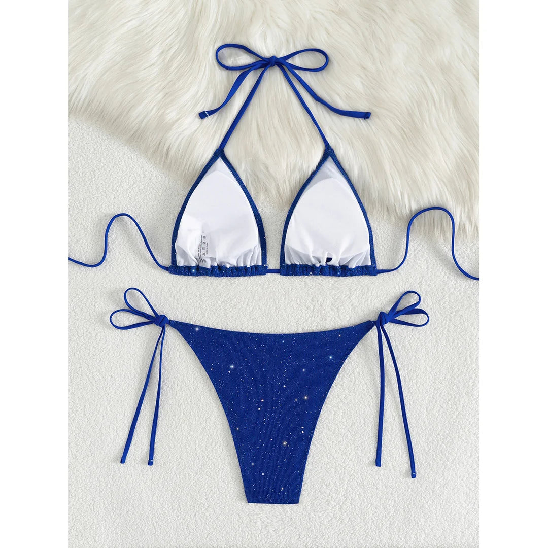 An elegant two-piece swimwear featuring a sparkling glitter finish, halter neckline, and high-leg cut, designed for a radiant and confident feminine beach look