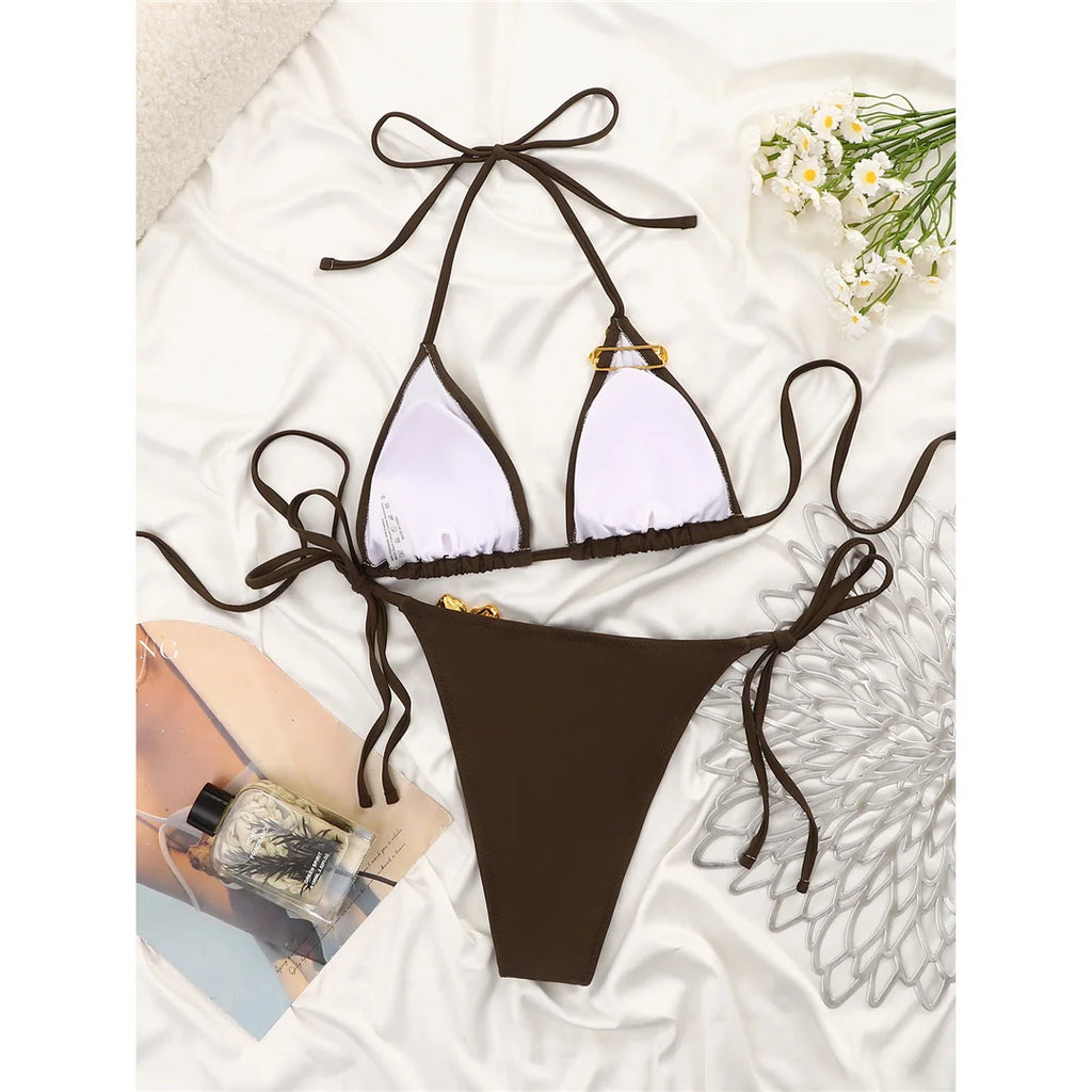 An elegant halter two-piece swimwear featuring delicate metal flower detailing and a flattering high-cut leg, designed for a feminine and refined beach statement