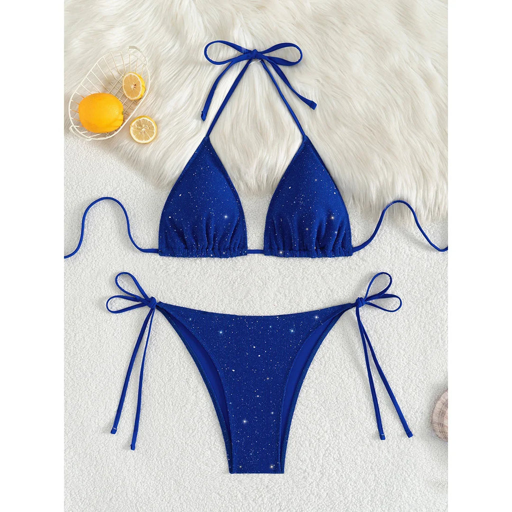 An elegant two-piece swimwear featuring a sparkling glitter finish, halter neckline, and high-leg cut, designed for a radiant and confident feminine beach look