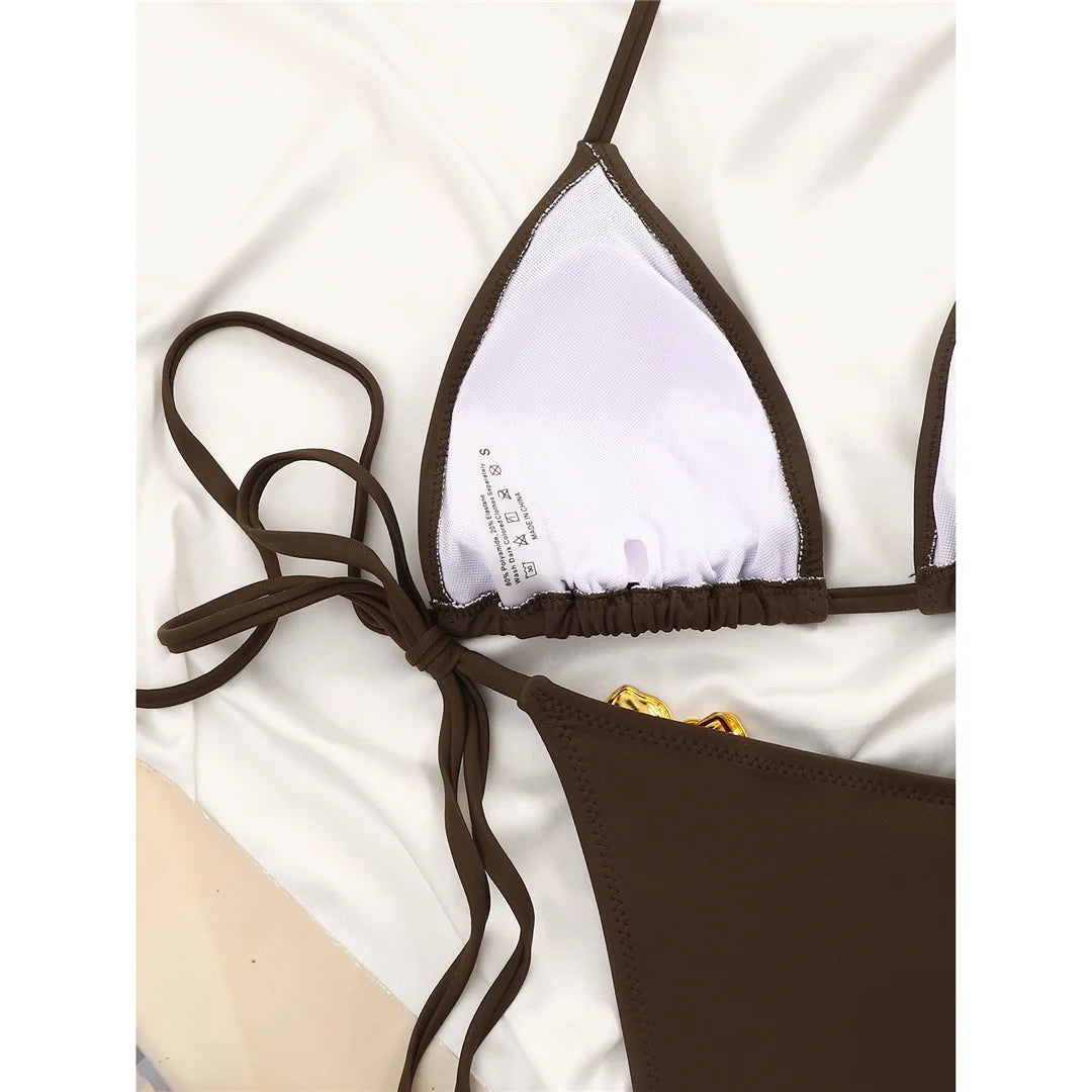 An elegant halter two-piece swimwear featuring delicate metal flower detailing and a flattering high-cut leg, designed for a feminine and refined beach statement