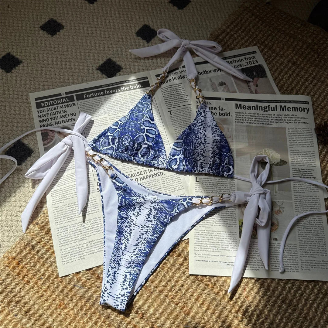 An elegant halter two-piece swimwear with a refined snakeskin-inspired print and strappy detailing, designed for a bold yet feminine beach look