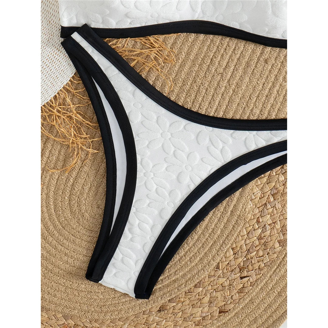 A refined two-piece swimwear featuring a padded top and flattering Brazilian high-cut leg, designed for an elegant and confident feminine beach look
