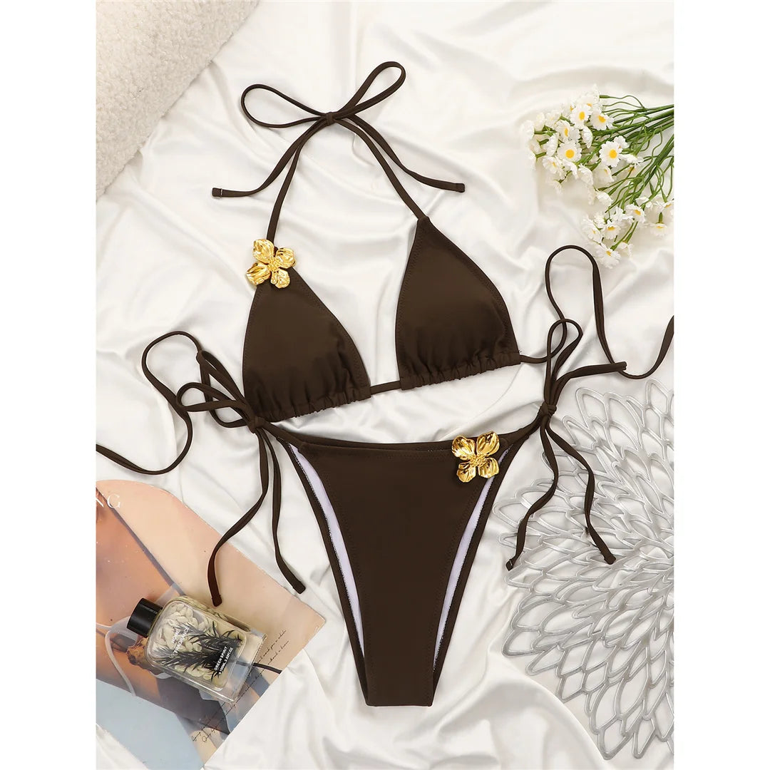 An elegant halter two-piece swimwear featuring delicate metal flower detailing and a flattering high-cut leg, designed for a feminine and refined beach statement