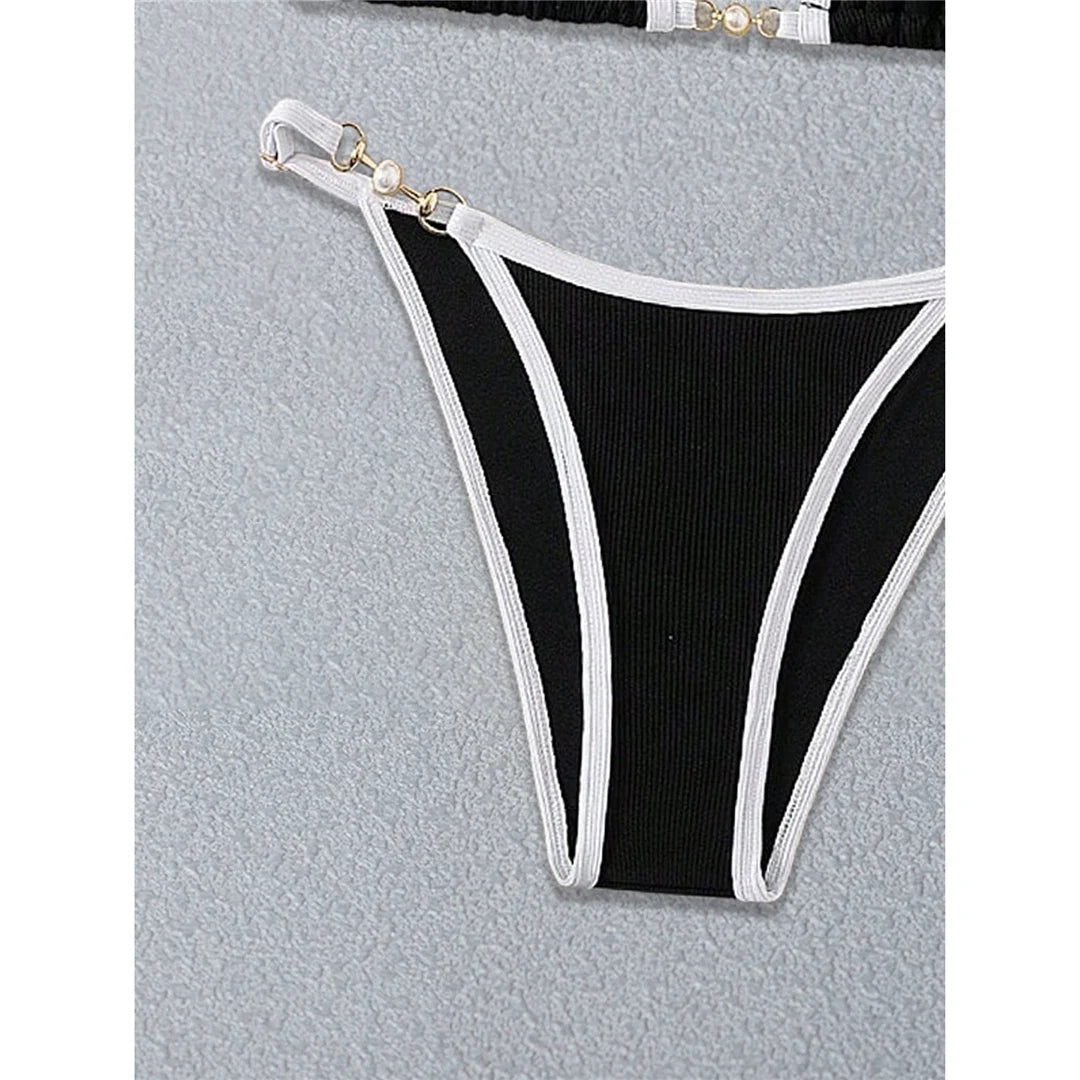An elegant two-piece swimwear featuring refined pearl accents, a ribbed texture, and a flattering high-cut silhouette, designed for a timeless and feminine beach look