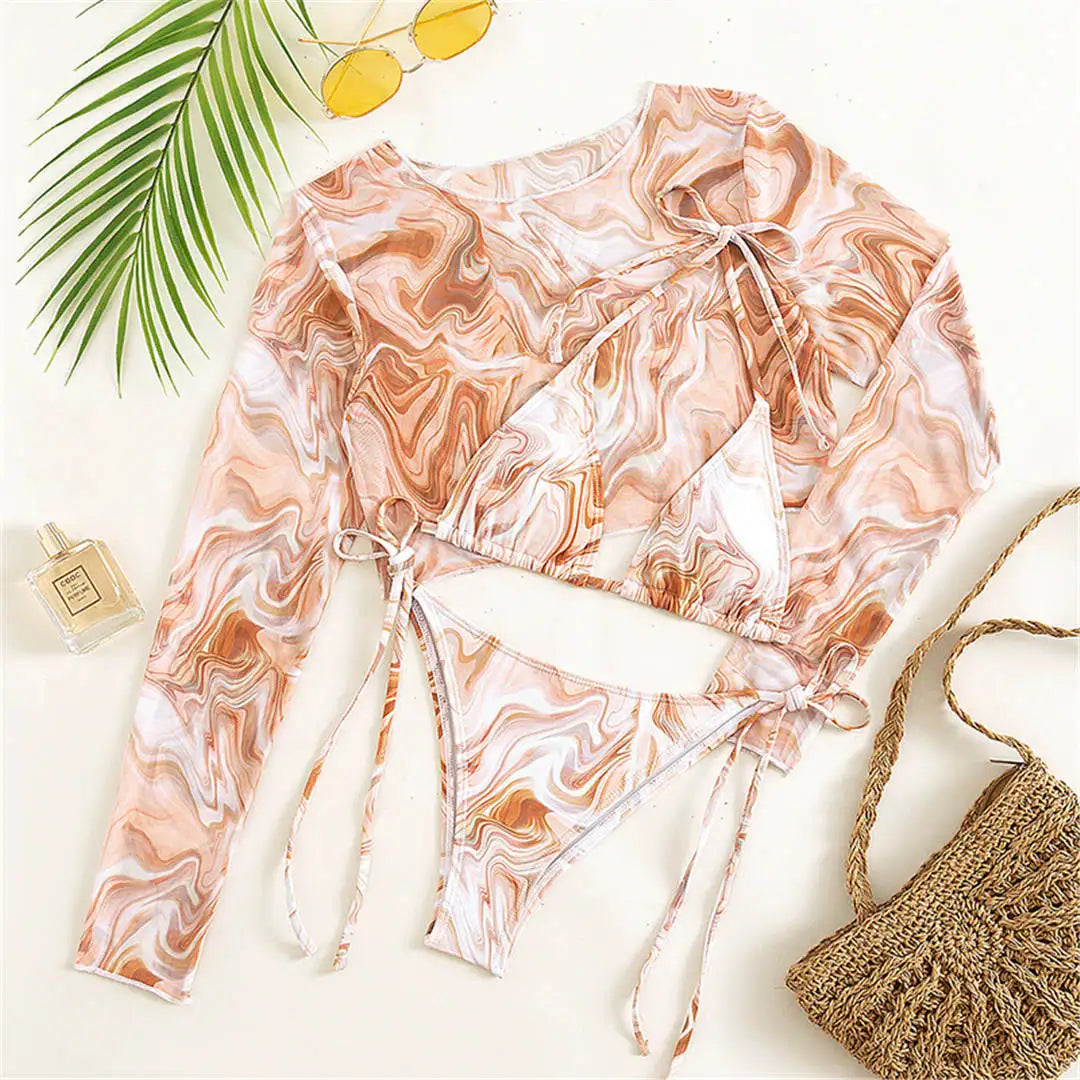 An elegant three-piece swimwear featuring a bold leopard print, long-sleeve top, and matching bikini set, designed for a feminine yet confident and stylish beach look