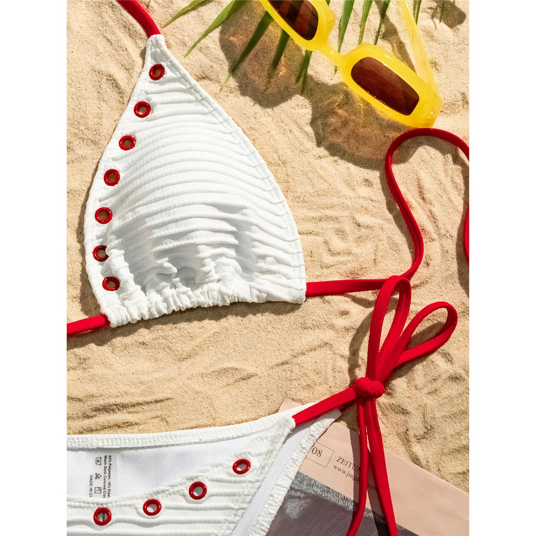 An elegant two-piece swimwear featuring a sleek halter design with strappy details and a high-cut leg, crafted for a bold yet feminine and refined beach look