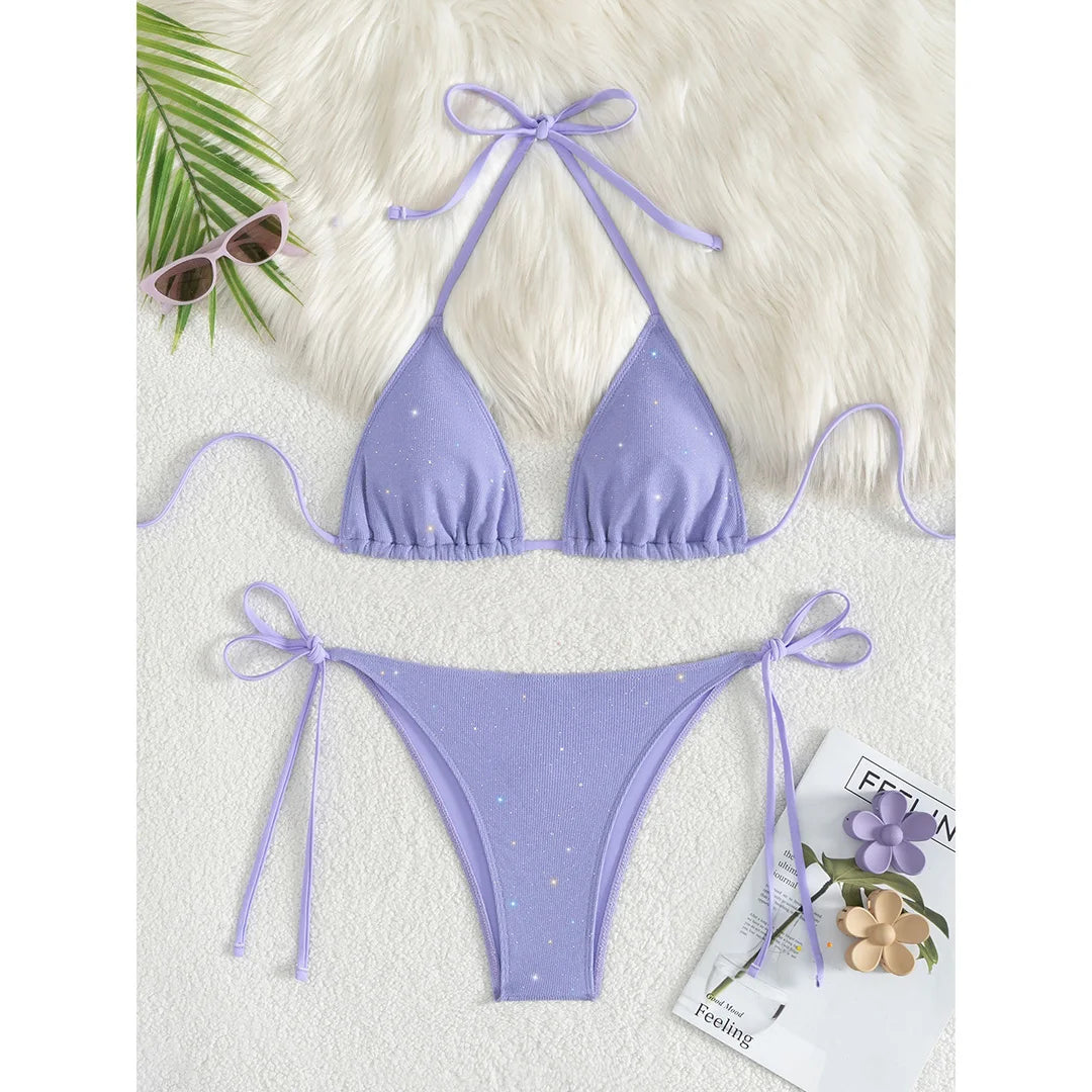 An elegant two-piece swimwear featuring a sparkling glitter finish, halter neckline, and high-leg cut, designed for a radiant and confident feminine beach look