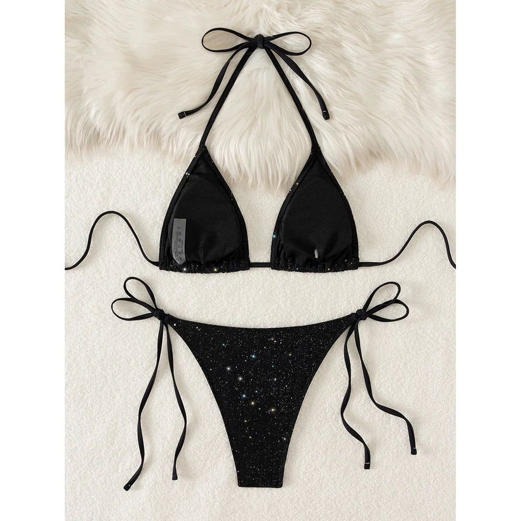 An elegant two-piece swimwear featuring a sparkling glitter finish, halter neckline, and high-leg cut, designed for a radiant and confident feminine beach look
