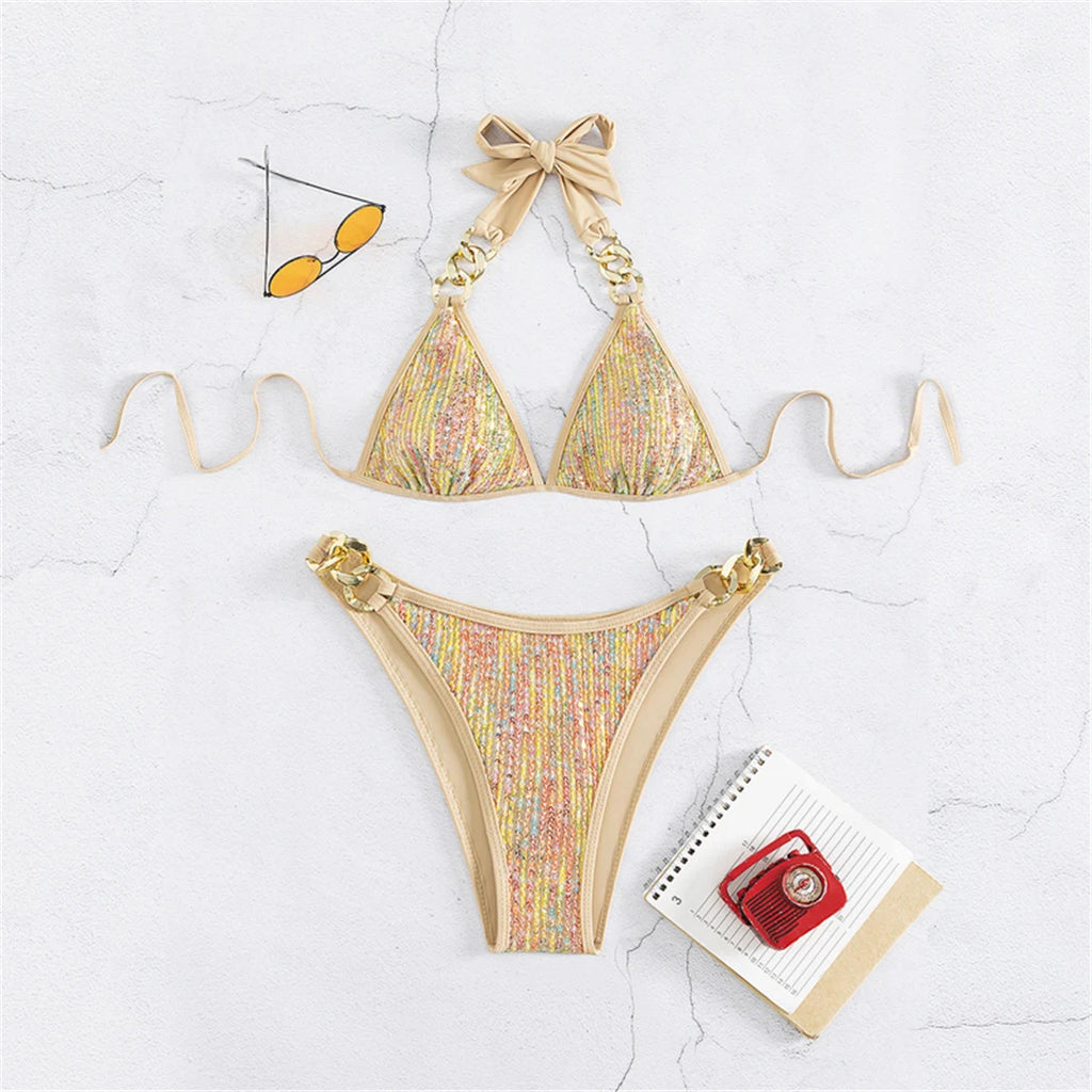 An elegant halter two-piece swimwear with shimmering sequin detail and refined metal ring accents, designed for a bold yet feminine beach statement