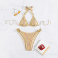 An elegant halter two-piece swimwear with shimmering sequin detail and refined metal ring accents, designed for a bold yet feminine beach statement