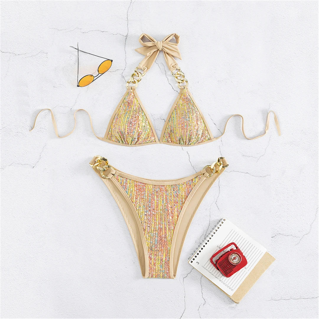 An elegant halter two-piece swimwear with shimmering sequin detail and refined metal ring accents, designed for a bold yet feminine beach statement