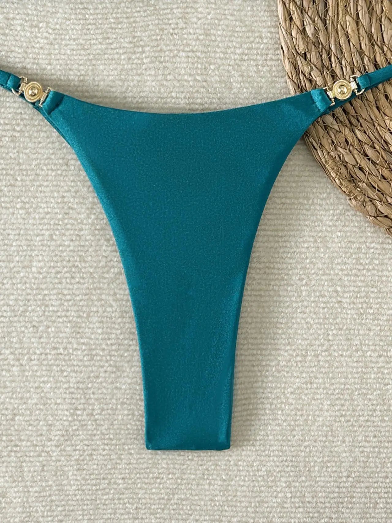 A sleek, shiny two-piece swimwear featuring a flattering push-up triangle top and Brazilian cheeky cut, designed for a bold yet elegant beach and vacation look