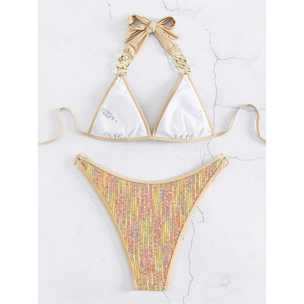 An elegant halter two-piece swimwear with shimmering sequin detail and refined metal ring accents, designed for a bold yet feminine beach statement