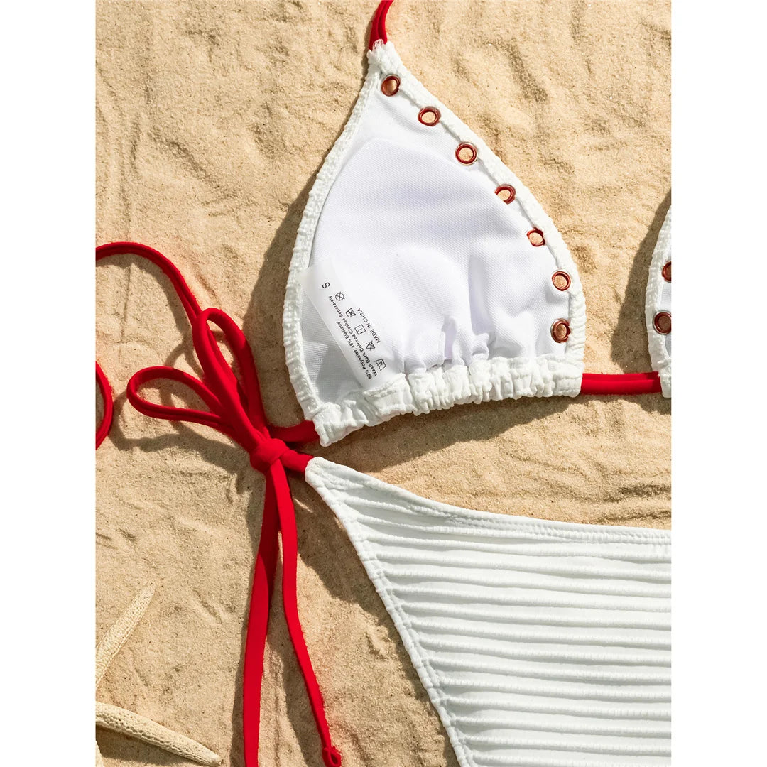 An elegant two-piece swimwear featuring a sleek halter design with strappy details and a high-cut leg, crafted for a bold yet feminine and refined beach look