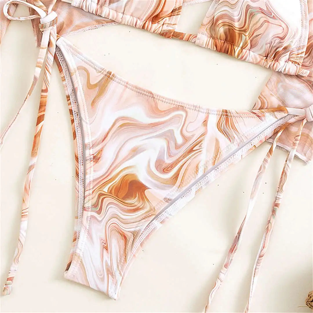 An elegant three-piece swimwear featuring a bold leopard print, long-sleeve top, and matching bikini set, designed for a feminine yet confident and stylish beach look