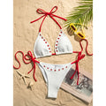 An elegant two-piece swimwear featuring a sleek halter design with strappy details and a high-cut leg, crafted for a bold yet feminine and refined beach look