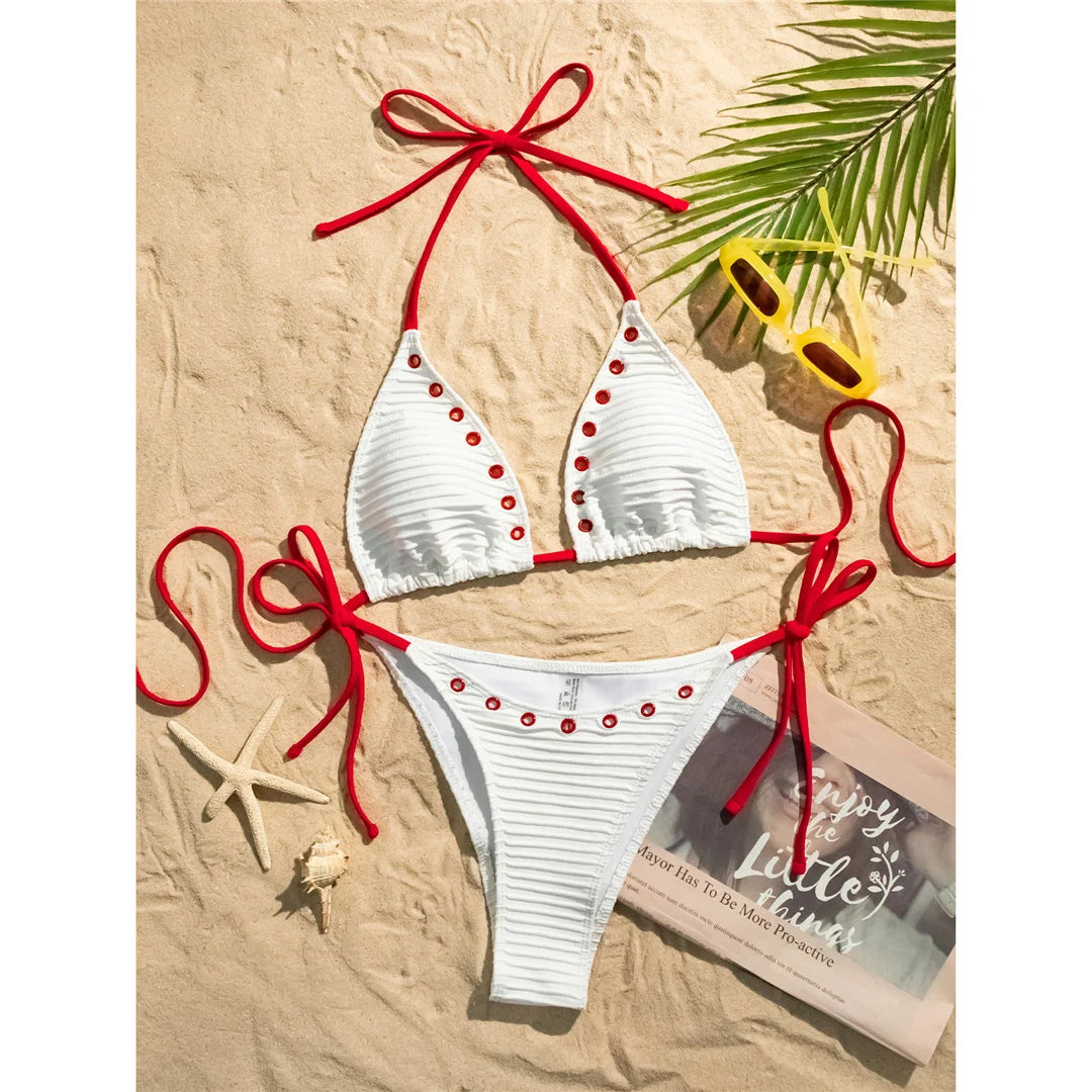 An elegant two-piece swimwear featuring a sleek halter design with strappy details and a high-cut leg, crafted for a bold yet feminine and refined beach look