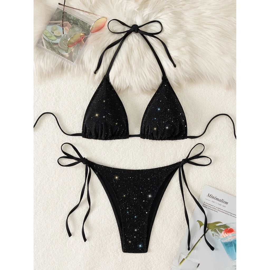 An elegant two-piece swimwear featuring a sparkling glitter finish, halter neckline, and high-leg cut, designed for a radiant and confident feminine beach look