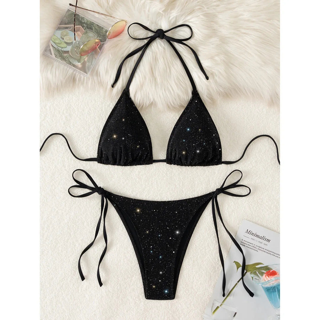 An elegant two-piece swimwear featuring a sparkling glitter finish, halter neckline, and high-leg cut, designed for a radiant and confident feminine beach look