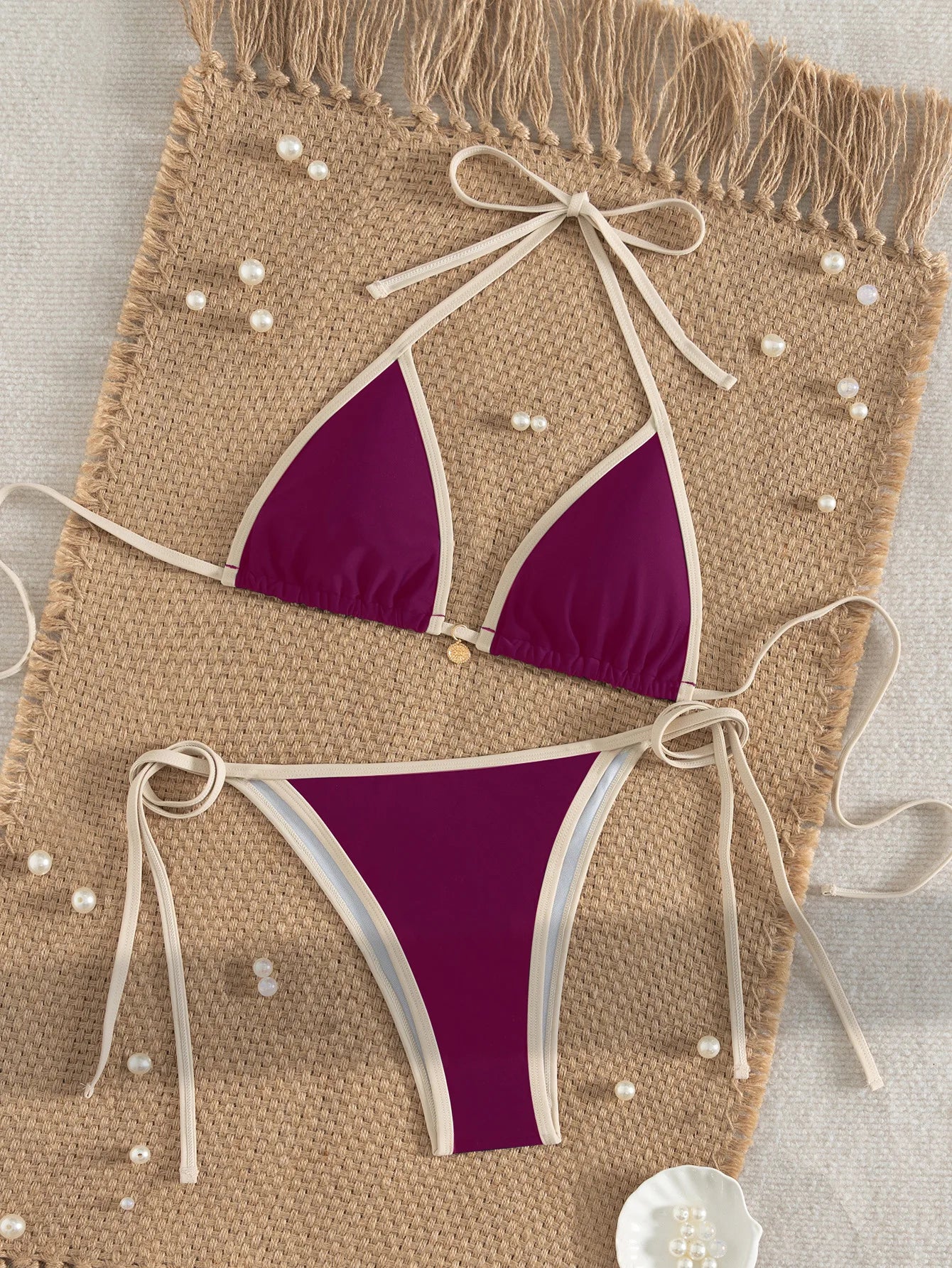 A modern two-piece swimsuit featuring elegant color-block detailing, tie-side accents, and a cross-back design, created for a confident and feminine beach look